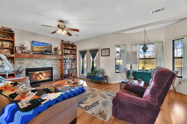 living room with light hardwood / wood-style flooring, a fireplace, ceiling fan, and french doors