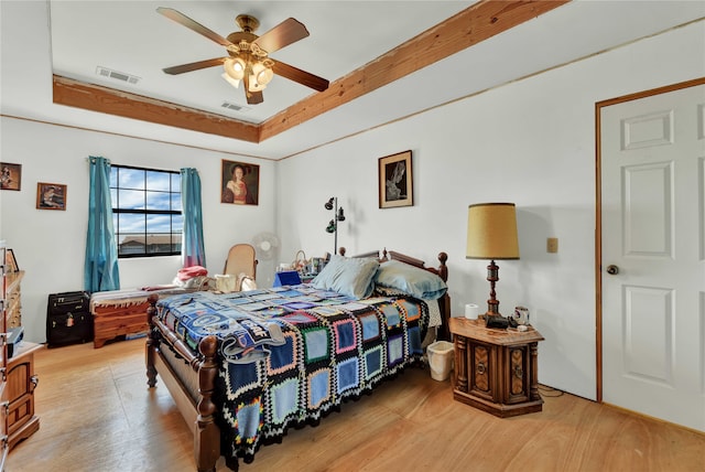 bedroom featuring a tray ceiling, light hardwood / wood-style flooring, and ceiling fan