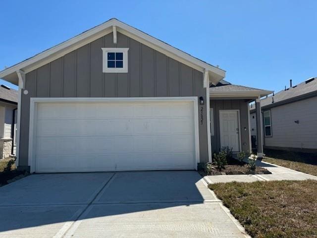 ranch-style house with an attached garage, board and batten siding, and driveway