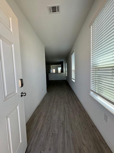 corridor with dark hardwood / wood-style flooring