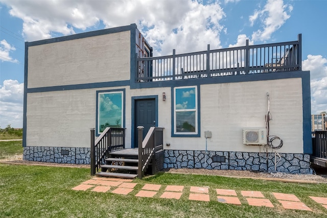 view of front facade featuring a front lawn and an AC wall unit