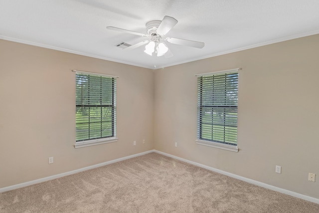 carpeted spare room featuring ceiling fan and ornamental molding