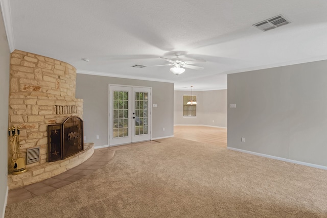 unfurnished living room featuring french doors, ceiling fan, a fireplace, carpet, and ornamental molding