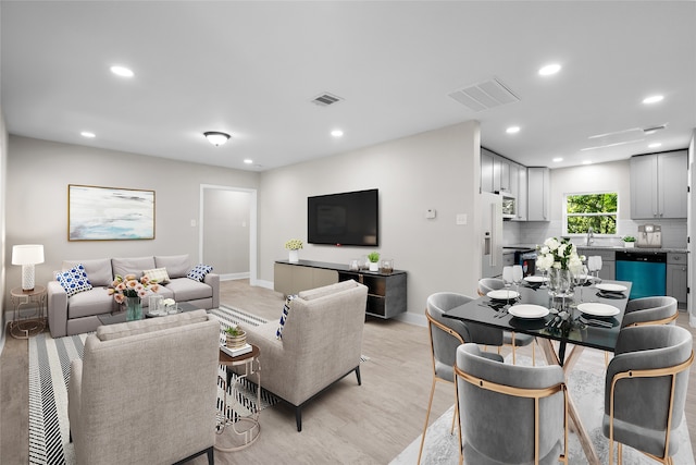 living room with sink and light hardwood / wood-style floors