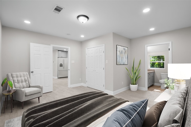 bedroom featuring connected bathroom, high end white refrigerator, a closet, and light wood-type flooring