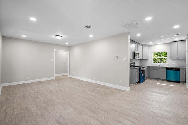 unfurnished living room with sink and light hardwood / wood-style flooring