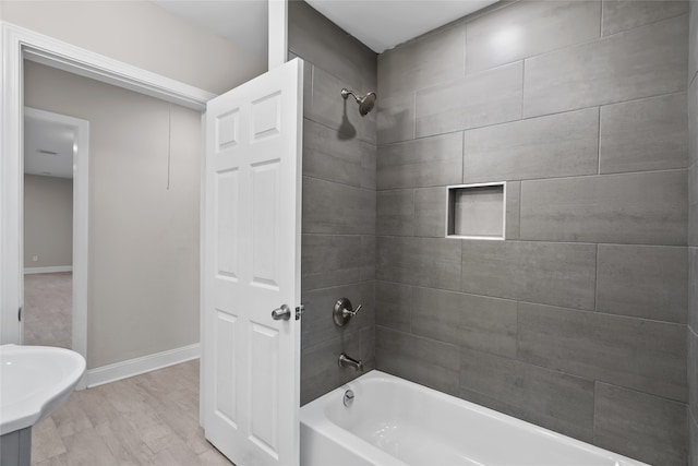 bathroom with tiled shower / bath and hardwood / wood-style floors