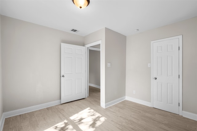 unfurnished bedroom featuring a closet and light wood-type flooring