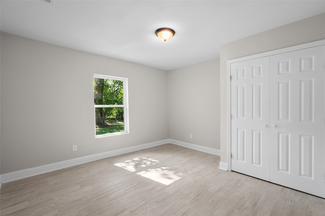 unfurnished bedroom with a closet and light wood-type flooring