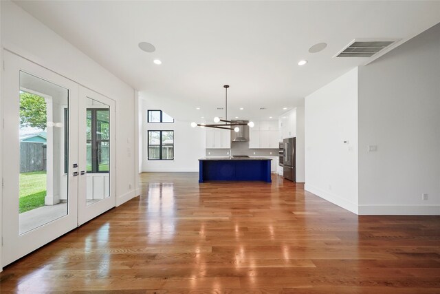 unfurnished living room featuring a notable chandelier and wood-type flooring