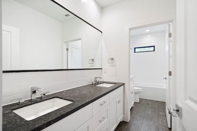 full bathroom featuring tiled shower / bath, vanity, tile patterned floors, toilet, and decorative backsplash