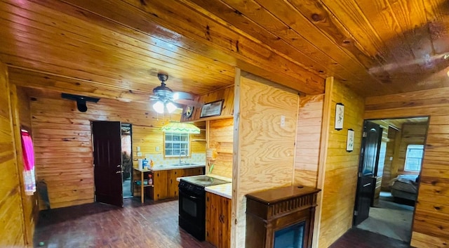 kitchen featuring wood walls, electric range, and ceiling fan