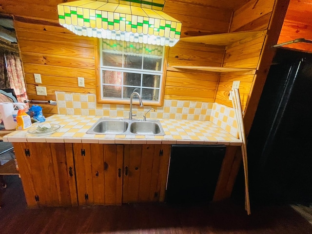 kitchen featuring tile counters, tasteful backsplash, wood walls, dark hardwood / wood-style floors, and sink