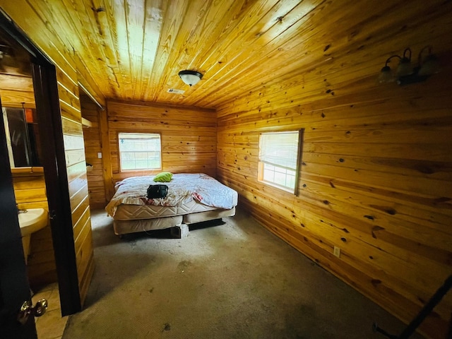 bedroom featuring ensuite bathroom, carpet, multiple windows, wood walls, and wooden ceiling