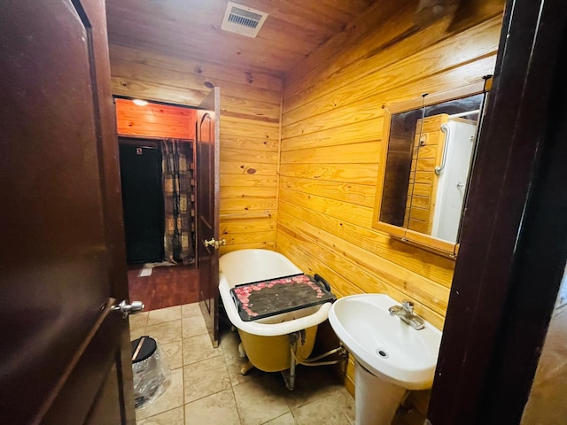 bathroom with sink, wood walls, wooden ceiling, and tile patterned flooring