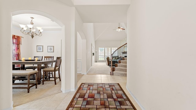 hall with an inviting chandelier, light tile patterned floors, and ornamental molding