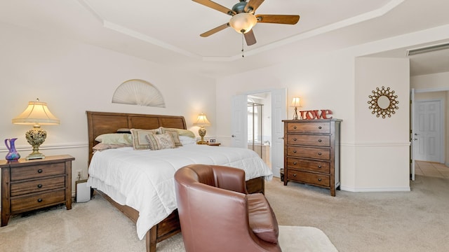 carpeted bedroom with ceiling fan and a tray ceiling