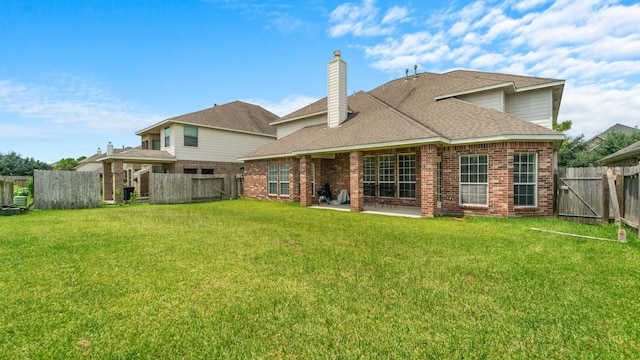 rear view of house with a yard and a patio