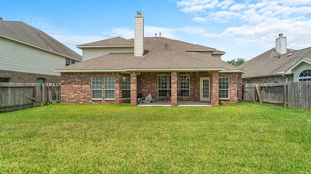 rear view of property featuring a patio and a lawn