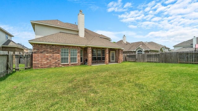 rear view of property with a yard