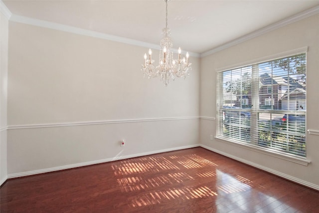 spare room featuring crown molding, dark wood-type flooring, and an inviting chandelier