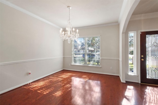 foyer entrance featuring a notable chandelier, a healthy amount of sunlight, dark hardwood / wood-style floors, and crown molding