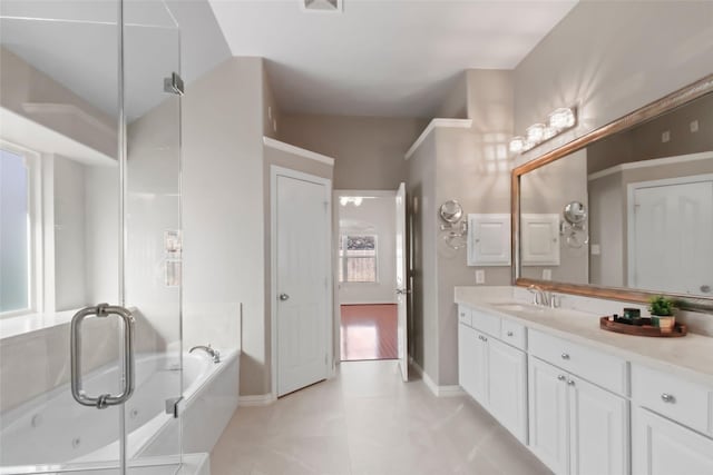 bathroom featuring tile patterned flooring, a bath, and vanity