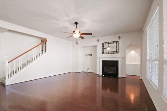 unfurnished living room featuring ceiling fan and dark hardwood / wood-style floors