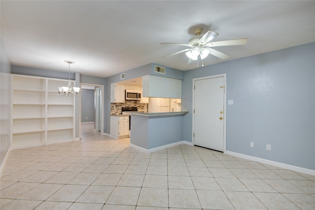 kitchen with light tile patterned floors, kitchen peninsula, ceiling fan with notable chandelier, hanging light fixtures, and decorative backsplash