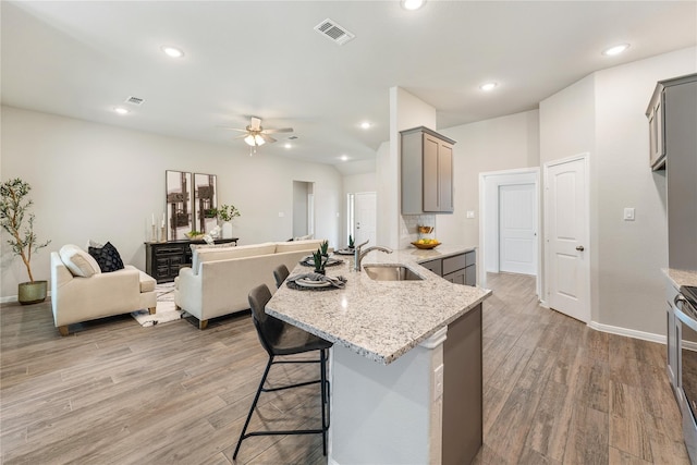 kitchen with sink, ceiling fan, light wood-type flooring, and gray cabinetry