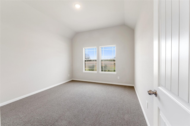 carpeted spare room featuring lofted ceiling