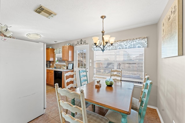 dining area with sink, a notable chandelier, and light tile patterned floors