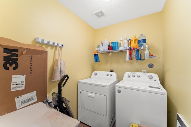 washroom with washer and clothes dryer and a textured ceiling