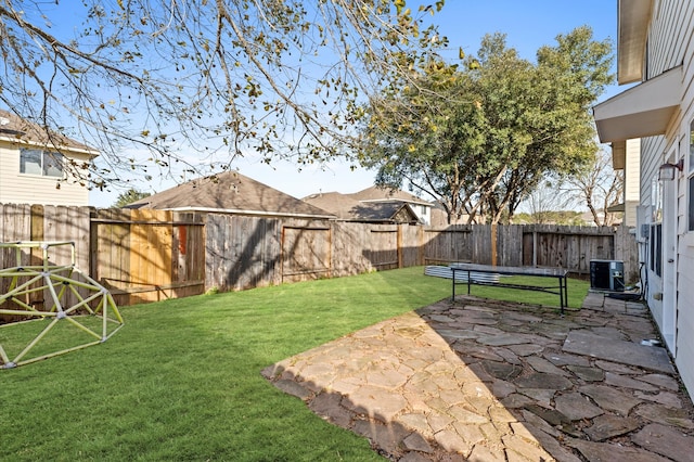 view of yard with central AC and a patio