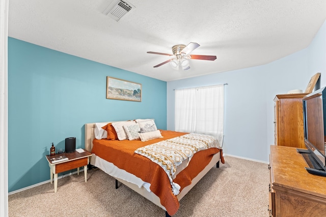 carpeted bedroom featuring a textured ceiling and ceiling fan