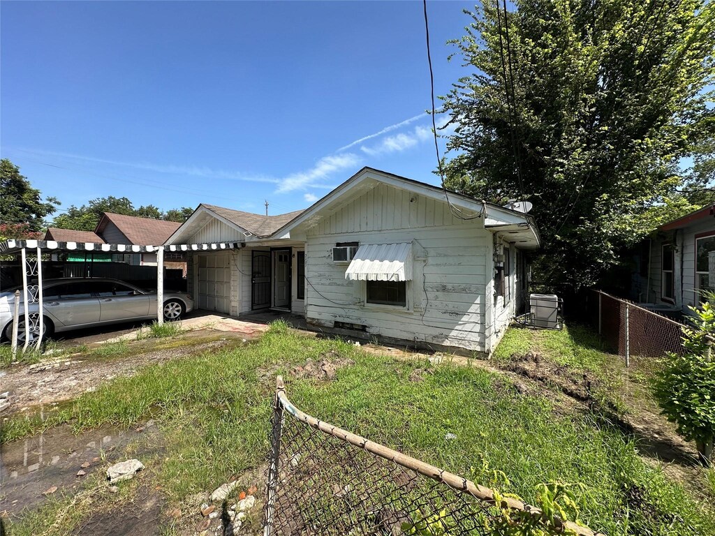 bungalow-style house with a front yard and a carport