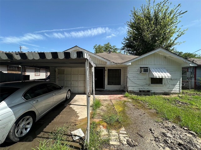 view of front facade with a wall mounted AC and a garage