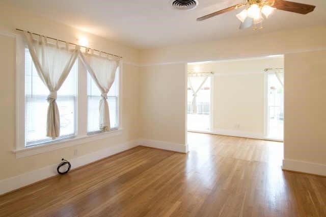 spare room with a wealth of natural light, wood-type flooring, and ceiling fan