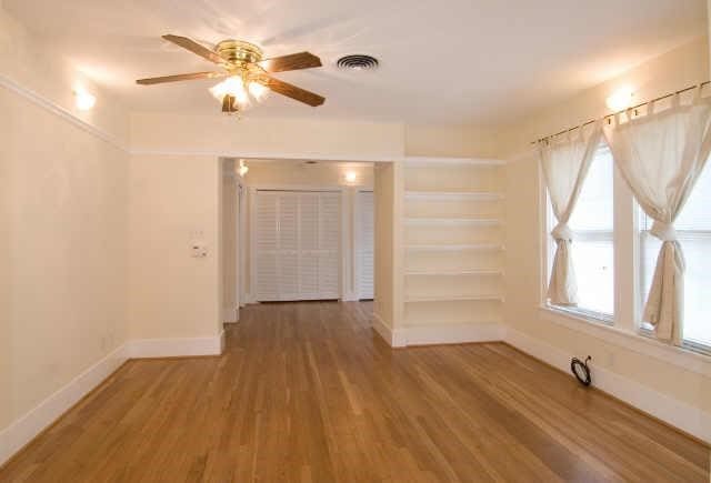 empty room with hardwood / wood-style floors and ceiling fan