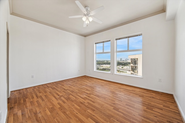 empty room featuring ceiling fan, hardwood / wood-style flooring, and ornamental molding