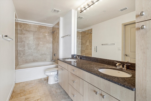 full bathroom with tile patterned flooring, tiled shower / bath combo, toilet, and dual bowl vanity