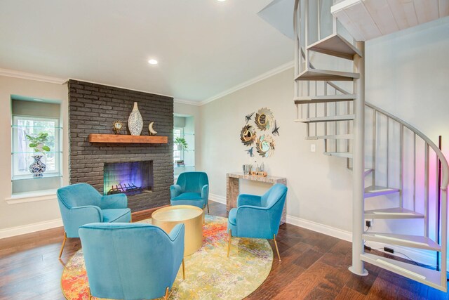 living room featuring crown molding, a fireplace, dark hardwood / wood-style flooring, and brick wall