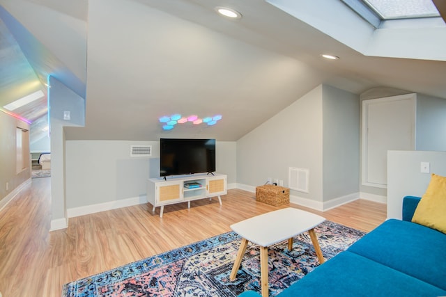 living room with wood-type flooring and lofted ceiling with skylight