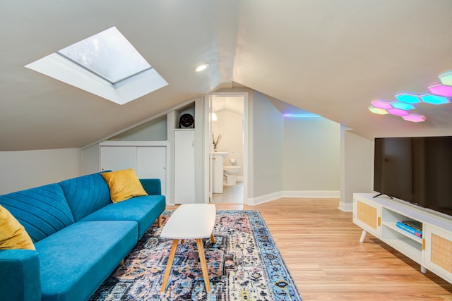 living room with lofted ceiling with skylight and light hardwood / wood-style floors