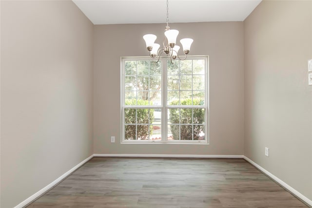 unfurnished dining area with plenty of natural light, baseboards, and wood finished floors