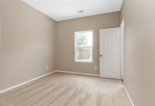 empty room with light carpet, baseboards, and visible vents