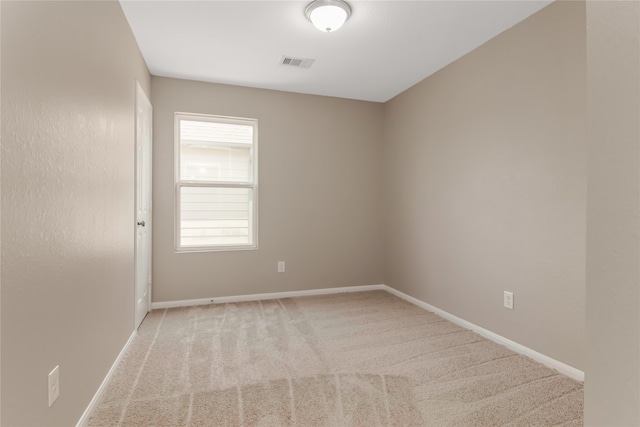 empty room featuring light carpet, baseboards, and visible vents