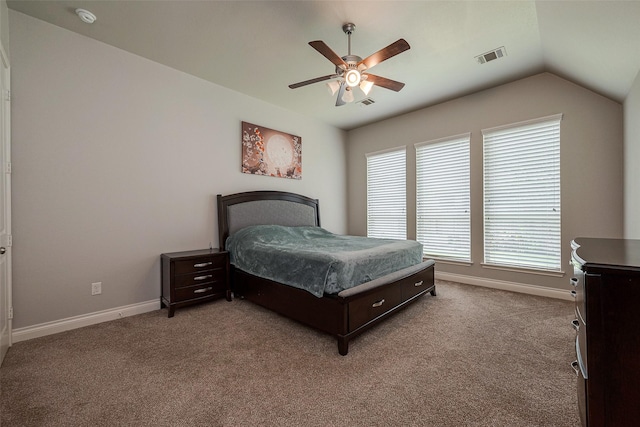 carpeted bedroom with visible vents, baseboards, lofted ceiling, and a ceiling fan