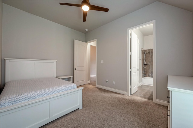 bedroom with light colored carpet, connected bathroom, baseboards, and a ceiling fan