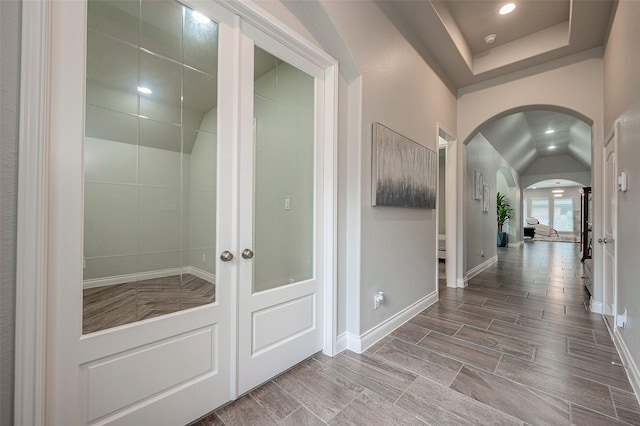 interior space with lofted ceiling, recessed lighting, french doors, arched walkways, and baseboards